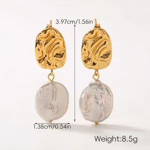 Gros plan détaillé de boucles d'oreilles perles baroques et monture dorée texturée