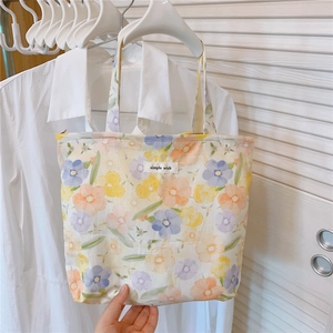 Détail macro du sac à main en coton floral avec étiquette simple wish sur un cintre