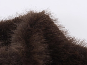 Close-up of luxury dark brown faux fur vest texture showing high-quality soft fibers