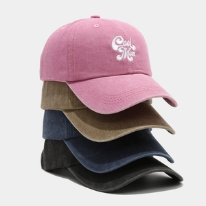 Detail of embroidered 'Cool Mom' text on washed cotton baseball caps in multiple colors