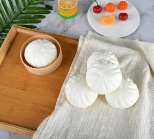 Realistic 8cm PU slow rebound bun toys displayed in a bamboo steamer on a marble surface