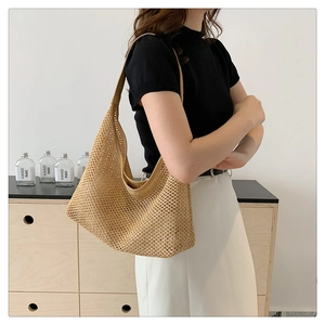 Detail of woven straw tote bag showing texture and drape in a modern home setting