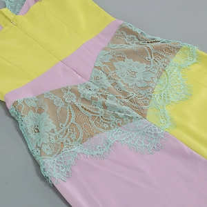 Close-up of white dress with yellow pink contrast stitching and mint green lace floral embroidery