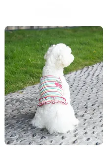 Detail of striped pet summer dress featuring cherry embroidery and red wavy hem on a small dog