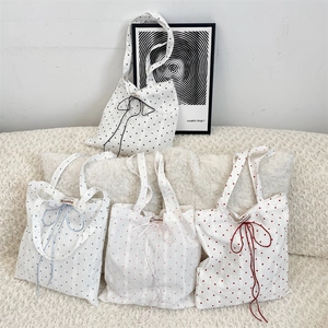 Detailed view of four colorful heart canvas tote bags with elegant bow-knot ribbons