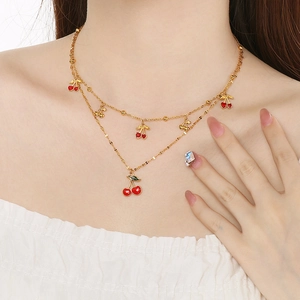 Détail du collier double rang doré avec pendentifs cerises porté pour un style de plage