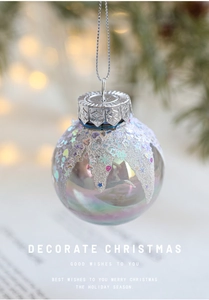 Close-up of iridescent Christmas ball with silver glitter and star sequins detail
