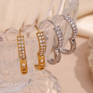Detail of 18K gold plated hoop earrings with double row rhinestones and heart cutouts