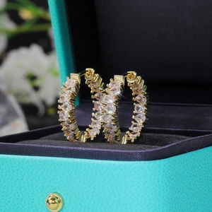 Detailed close-up of 18K gold hoop earrings with pear-cut cubic zirconia in a gift box