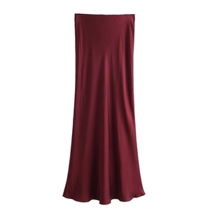 Détail d'une jupe midi en satin bordeaux montrant la texture soyeuse et le drapé