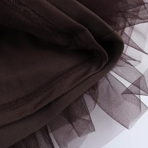 Detail of dark brown knit fabric with delicate mesh tulle stitching and clean hemline