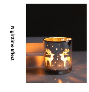 Detail of silver reindeer glass candle holder showing glowing warm light through star cutouts