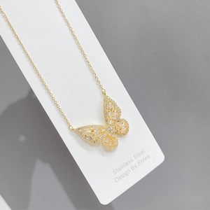 Detailed close-up of golden hollow butterfly pendant necklace with sparkling cubic zirconia