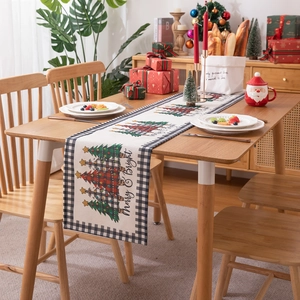 Modern Christmas tree table runner with Merry & Bright text on a festive wooden dinner table