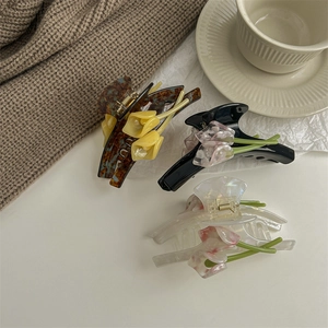 Three elegant tulip flower acetate hair claws with premium metal springs in soft lighting