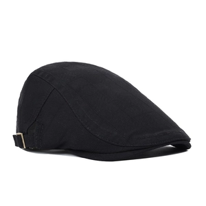Detail of classic black newsboy cap featuring subtle grid texture and vintage metal side buckle
