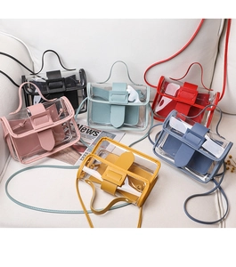 Multiple colorful transparent PVC jelly handbags displayed on a white textured surface