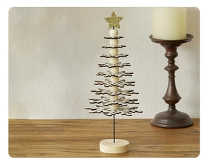 Detailed view of mini wooden Christmas tree with white snowflakes and golden star top