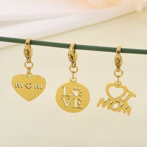Detail view of golden MOM heart charms with lobster clasp on white silk texture