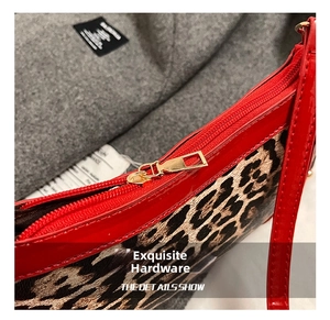 Close-up of golden metal zipper hardware on leopard print bag with red leather trim