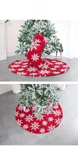 Detail of red plush Christmas tree skirt and matching stocking with white snowflakes