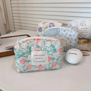 Detailed close-up of French floral cotton quilted makeup bag with pink rose patterns