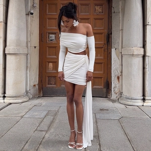 Detail of white two-piece set with long sleeve off-shoulder top and draped mini skirt