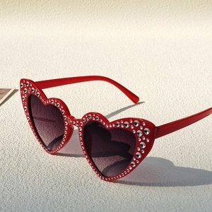Detailed shot of red heart-shaped kids' sunglasses with sparkling rhinestone borders
