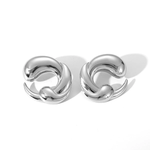 Detailed view of chunky silver twisted C-shape earrings with a polished mirror finish