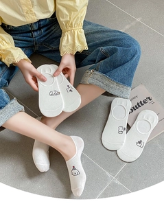Detailed view of white cotton low cut socks with cute embroidered cartoon dog patterns