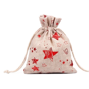 Close-up of beige linen gift bag with red glitter star patterns and drawstring closure