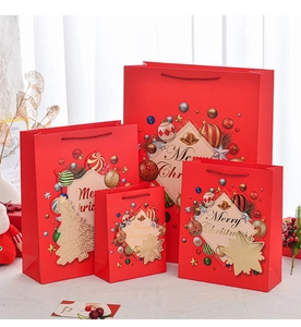 Detail view of four sizes of red Christmas gift bags with bells and pine patterns