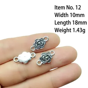 Detailed size view of silver floral connectors on fingertip for jewelry making DIY