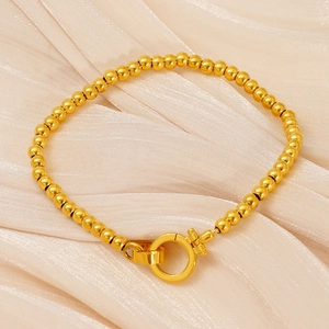 Bracelet élégant en perles d'acier inoxydable doré avec fermoir à ressort rond sur velours