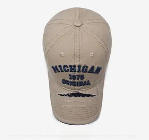 Detailed close-up of khaki baseball cap featuring blue Michigan 1975 embroidery and distressed brim