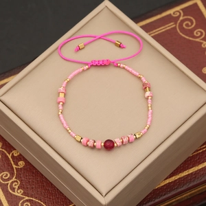 Handmade bohemian beaded bracelet featuring pink natural stones and golden metal accents