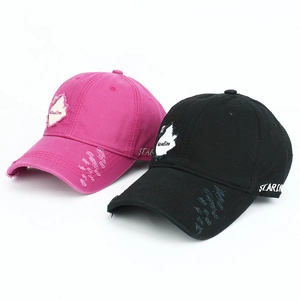 Close-up of distressed cotton baseball caps with Woodlife embroidery and torn details