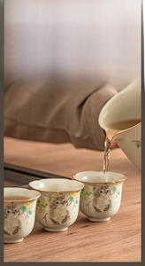 Macro detail of Ru ware ceramic tea cup with cute cat illustration and flower patterns