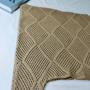 Close-up of khaki crochet knit tote bag showing intricate hollow square patterns