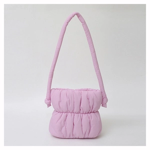 Close-up of pink puffy nylon shoulder bag showing pleated texture and soft quilted material