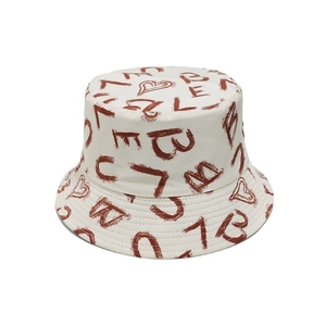 Dettaglio del motivo a cuore ricamato e delle lettere marroni artistiche sul cappello