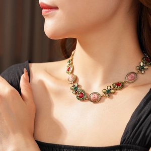 Détail d'un collier camée vintage avec pierre cœur rouge et accents floraux