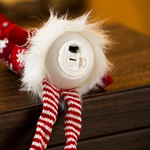 Detail of Christmas gnome plush bottom featuring battery compartment with on-off switch