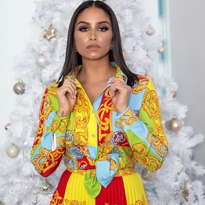 Detalle del estampado barroco dorado en conjunto de camisa de manga larga y falda plisada
