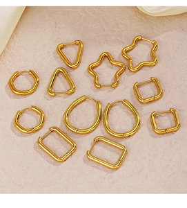 Selection of geometric gold earrings in star, triangle, and square shapes on silk
