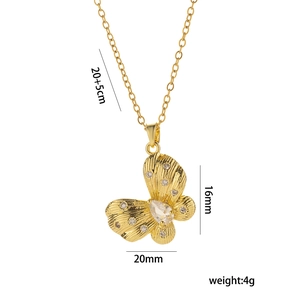 Collier avec pendentif papillon doré et pierres en zircon blanc sur fond blanc