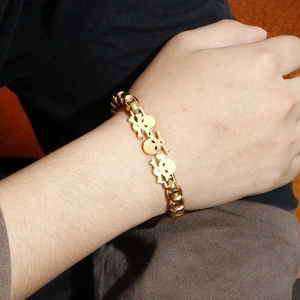 Detail showing a gold skull bracelet for men in hip hop style worn on the wrist