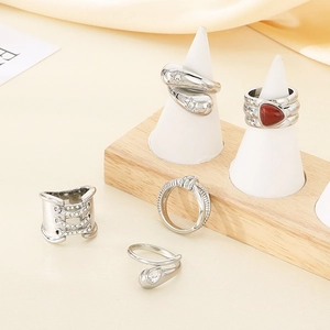 Detail shot of 18K gold plated teardrop diamond rings on a wooden display stand