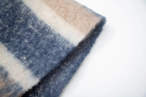Close-up of soft plush leopard print scarf fabric showing blue and beige patterns