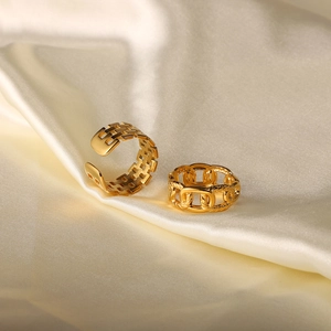 Detail of 18k gold plated stainless steel twist chain and geometric open rings on beige silk